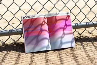 Open Book Mockup Against a Fence