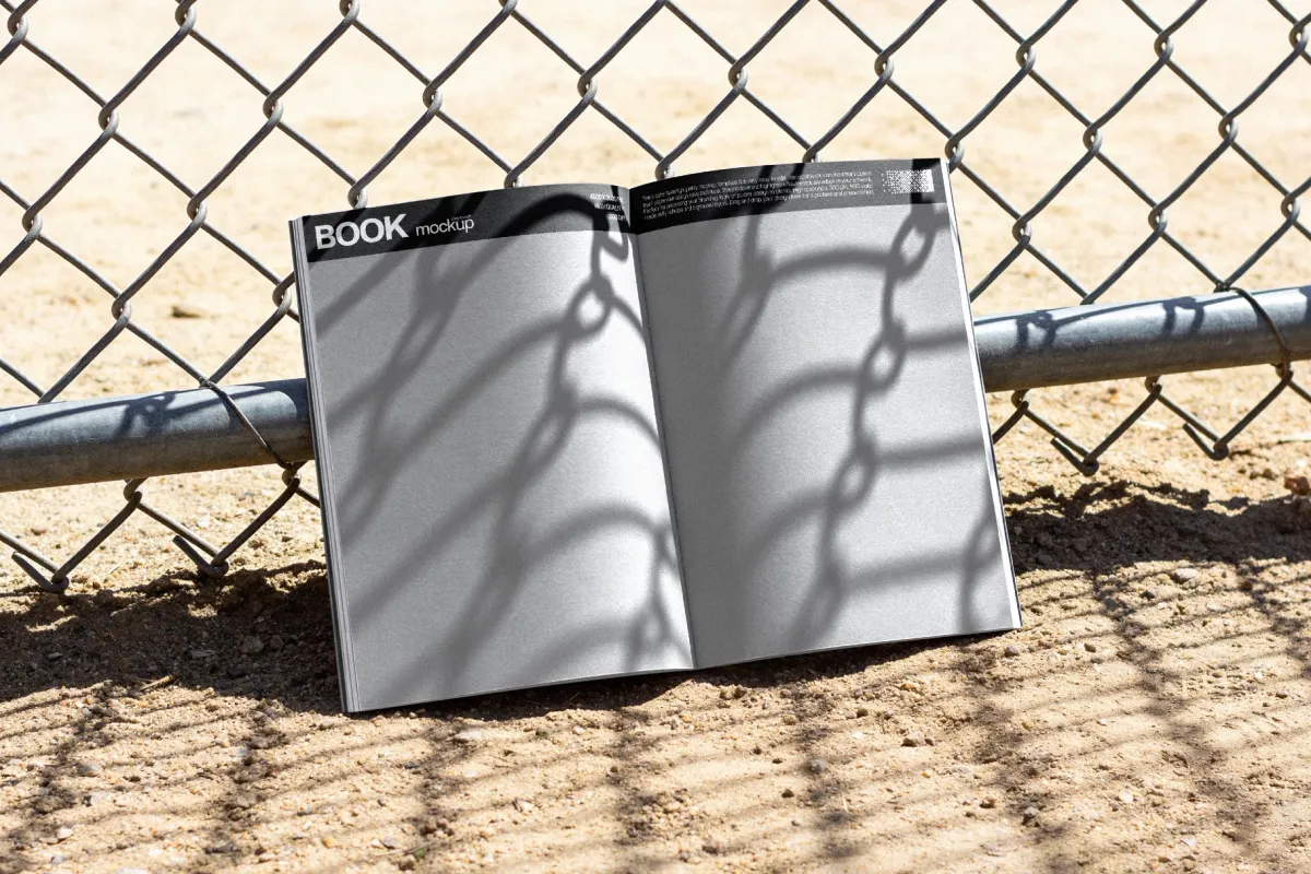 Open Book Mockup Against a Fence